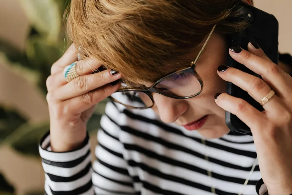 An anxious woman on a scam phone call