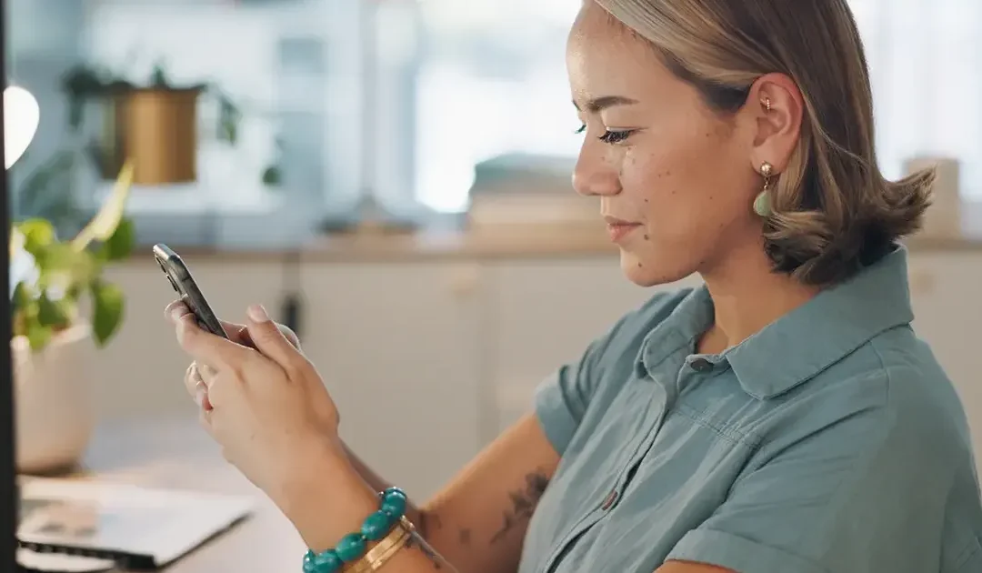 An adult woman woman holding a mobile device with both hands